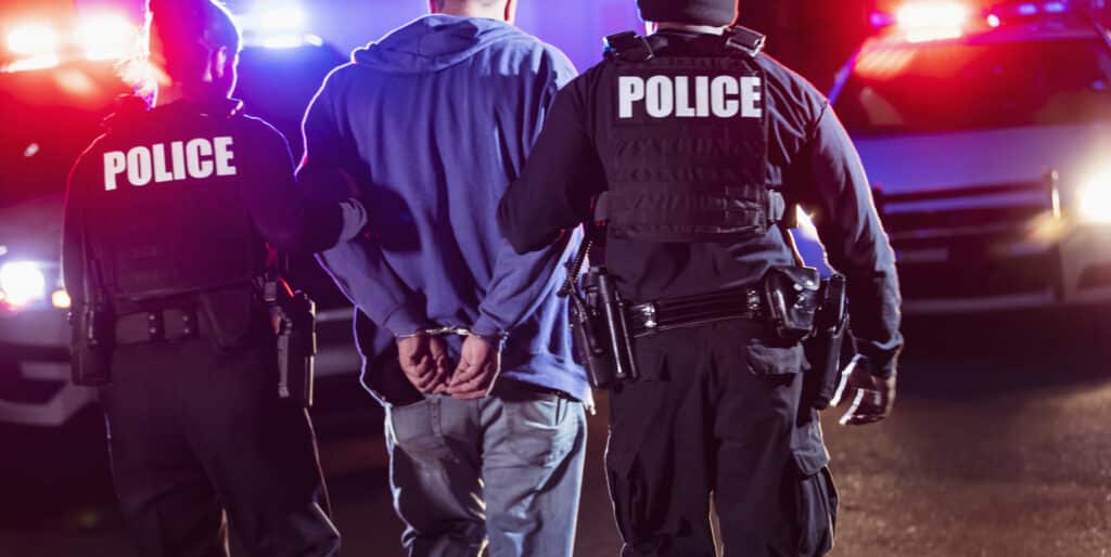 Second Degree Murder 1 Handcuffed suspect being arrested by police at night